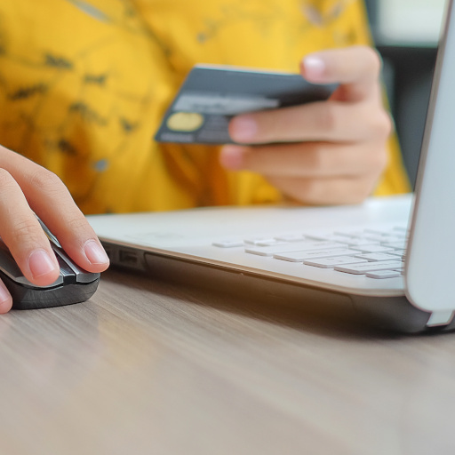 Asian woman holding credit card and using laptop for online shopping while making orders. internet, technology, ecommerce and online payment concept