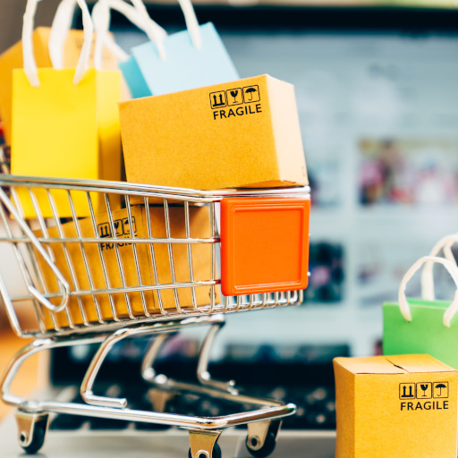 Product package boxes and shopping bag in cart with laptop computer which web store shop on screen for online shopping and delivery concept