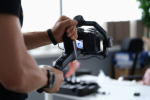 Videographer shooting video on camera from tripod closeup. 